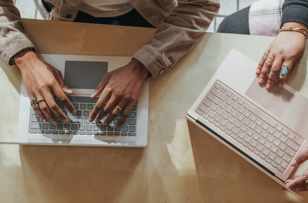 Two people typing on laptops to show skills