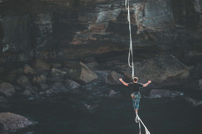 man walking across a tightrope 