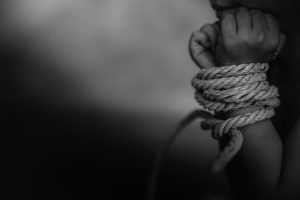 Hands bound by rope black and white illustrating modern slavery