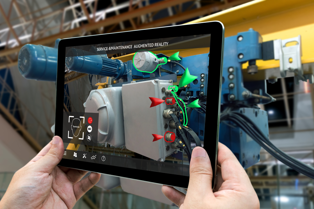 Hands holding tablet that demonstrates AR learning for engine repair