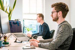 Two men at a desk in an office, learning in the workflow