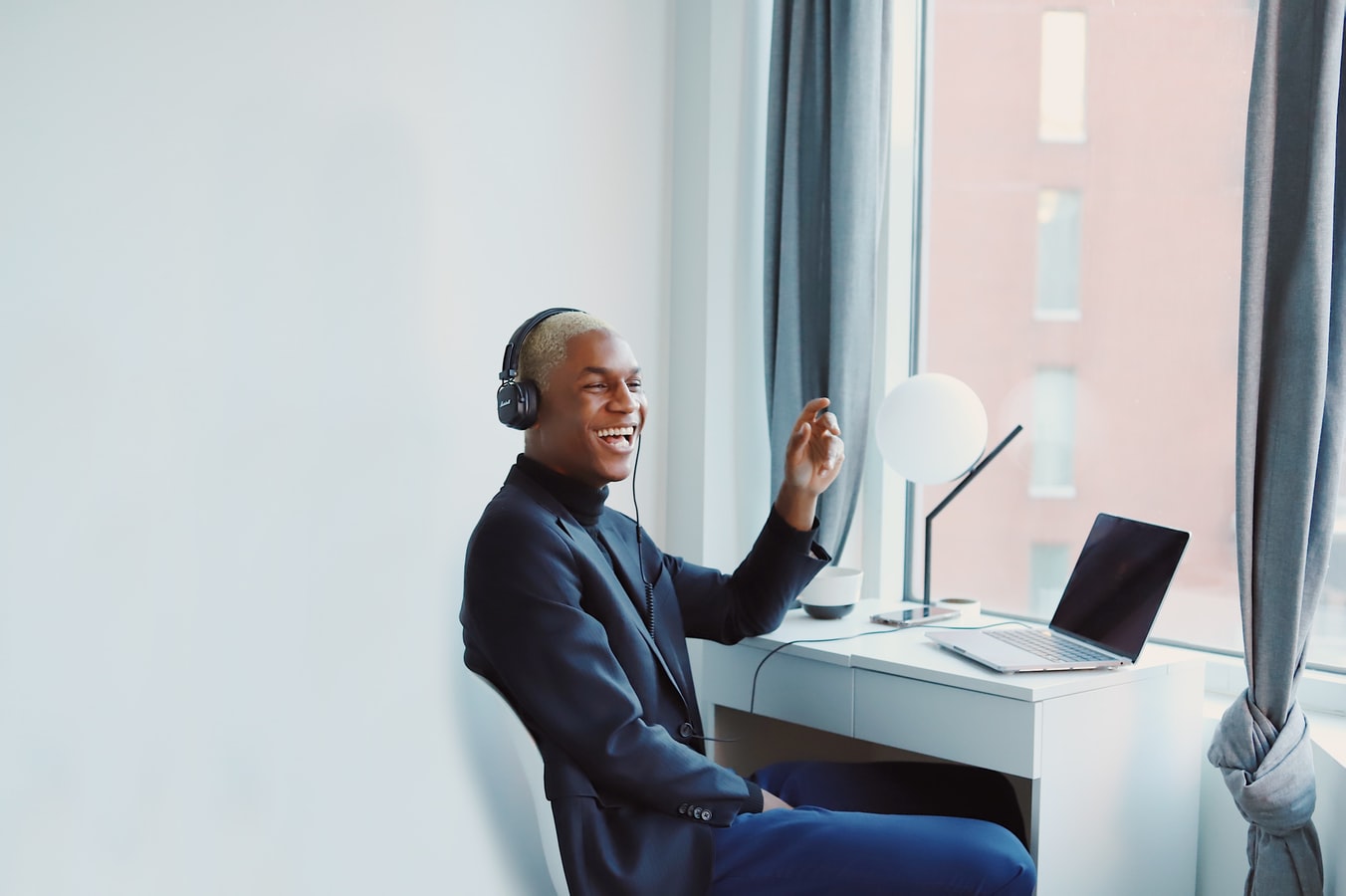 Guy sitting at desk with headset lauughing