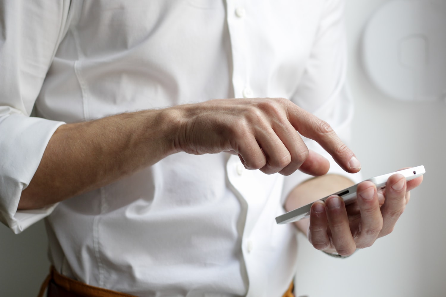 white man in white shirt holding phone