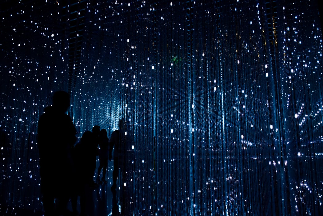 people in the dark surrounded by blue lights