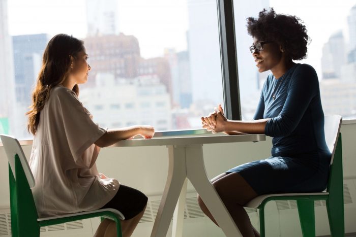 two women having an emotionally intelligent coaching discussion in the workplace 