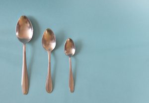 three spoons of different sizes on a blue background